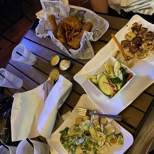Fried cod basket with sweet potato fries, grilled shrimp with veggies and Caesar salad