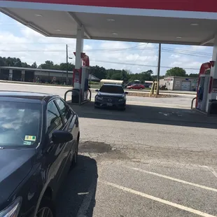 a black car parked in front of a gas station