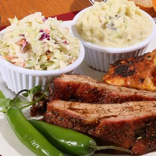 a plate of ribs, coleslaw, and hot dogs