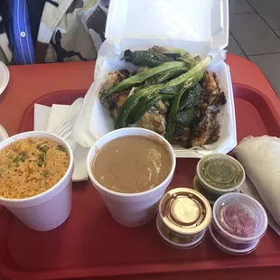 a tray of food with rice, beans, and other condiments