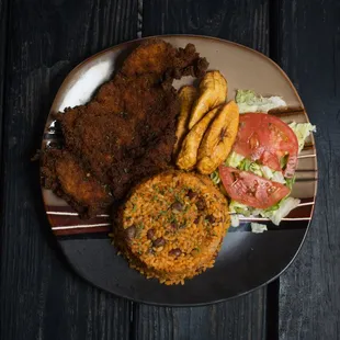 a plate of fried chicken, fries, tomatoes and lettuce