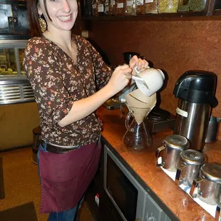 a woman pouring a cup of coffee
