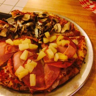 a pizza with pineapples and ham