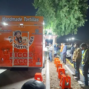 a line of people waiting to get their tacos