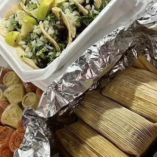 a plate of tamales and a bowl of salsa
