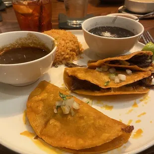 These are the brisket Birria tacos. He did them in the sauce and they were amazing. The black beans and the rice as well.