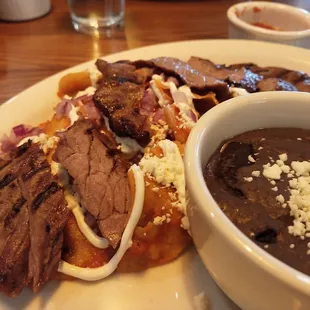 Chilaquiles with Carne Asada and a side of refried black beans