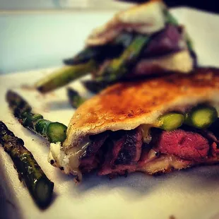 a steak sandwich and asparagus