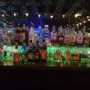 a row of liquor bottles on a bar