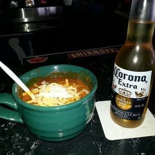 a bowl of soup and a bottle of corona extra