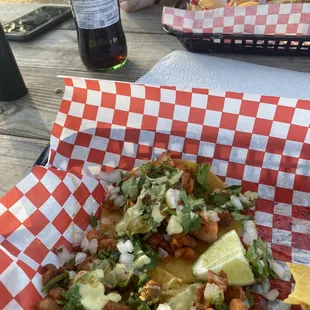 a plate of nachos and a bottle of beer