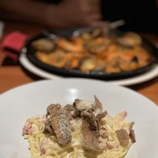 Carbonara with seafood paella in back