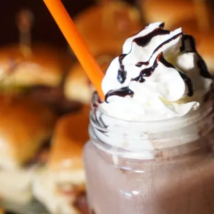 a hot chocolate drink with whipped cream and chocolate syrup