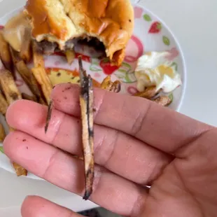 a hand holding a half eaten sandwich