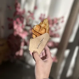 a person holding a pastry in their hand