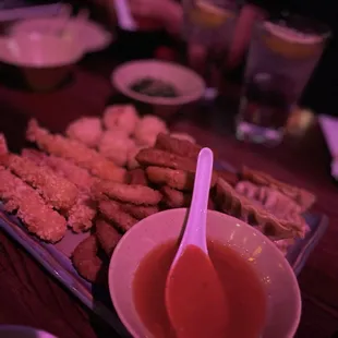 a plate of sushi with dipping sauce