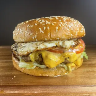 a cheeseburger on a wooden cutting board