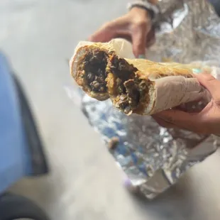 a person holding a sandwich