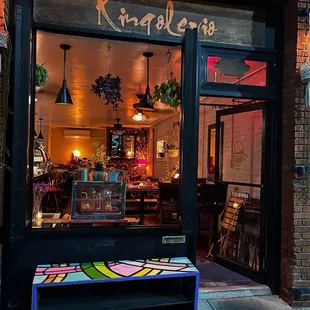 a colorful bench in front of a restaurant