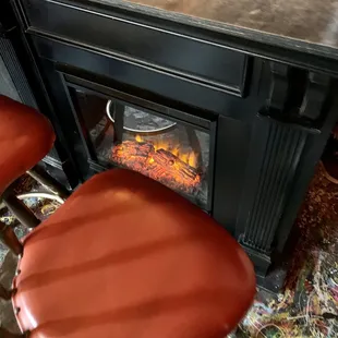a bar with two stools and a fire place