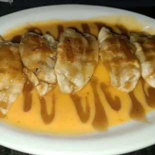 a plate of dumplings with sauce