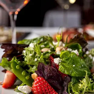 a plate of salad and a glass of wine
