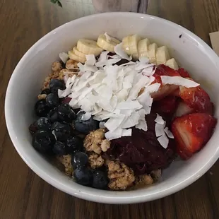 The Rio Bowl, large in a glass bowl. Has strawberries, blueberries, bananas, granola, coconut shavings, honey, and açaí