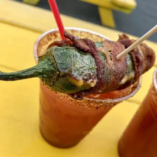 bacon wrapped in bacon on top of a bloody drink