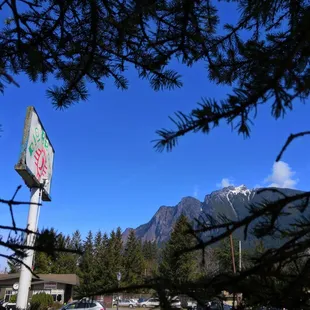 a stop sign in a parking lot with mountains in the background