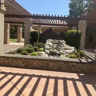 a pergolated pergolated patio with a water feature