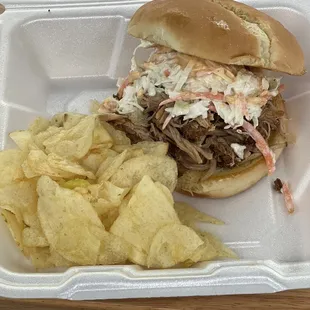 a pulled pork sandwich and chips