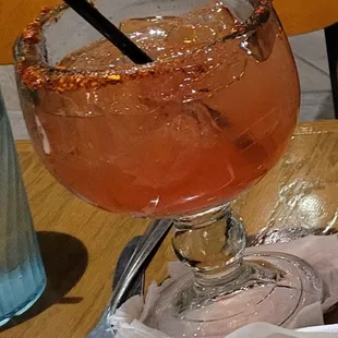 Strawberry margarita on the rocks with tajin rim
