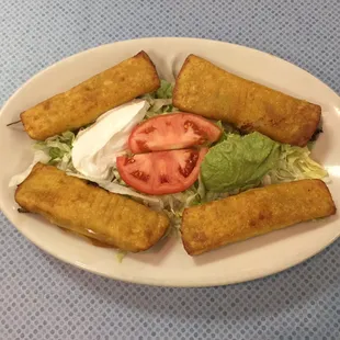 Taquitos Mexicanos,                                           2 beef and 2 chicken taquitos with lettuce, guacamole, tomato, and sour cream