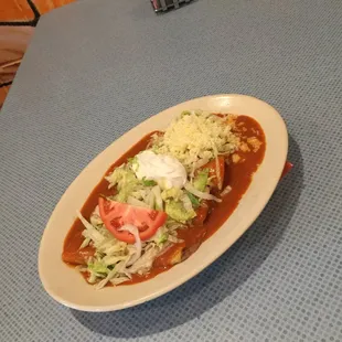 Enchilada Supreme : 1 chicken, 1 cheese, 1 bean, and 1 ground beef enchilada served with lettuce, sour cream, and shredded cheese.