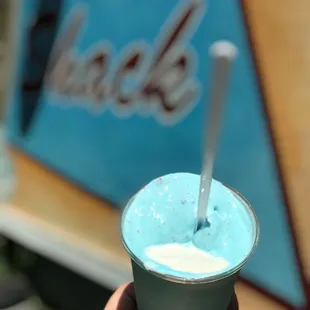 a hand holding a cup of ice cream