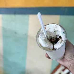 a hand holding a cup of ice cream