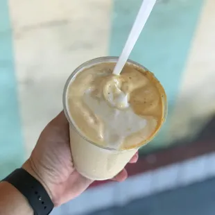 a hand holding a drink