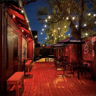 a wooden deck with tables and umbrellas