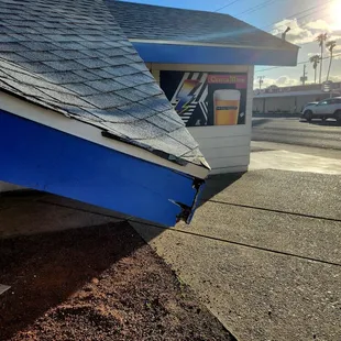 a blue and white boat sitting on the side of a building