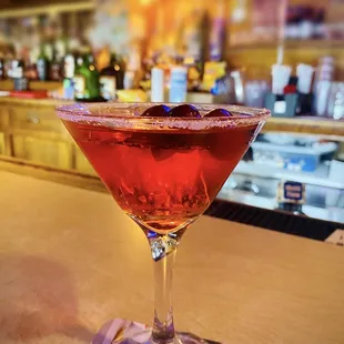 a red cocktail in a martini glass