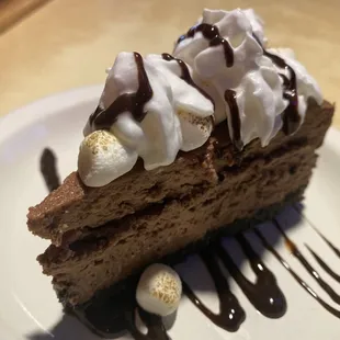 a piece of cake with whipped cream and chocolate sauce