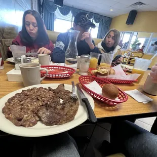 eople sitting at a table with food