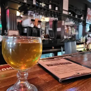 a glass of beer on a bar