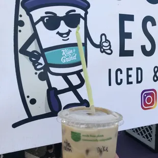 a hand holding a cup of iced coffee