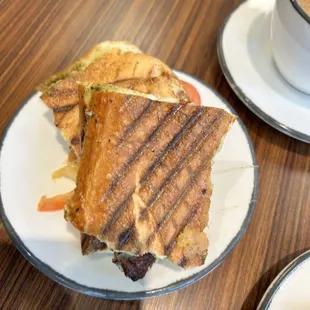 a grilled sandwich and a cup of coffee