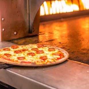 a pizza being cooked in a brick oven