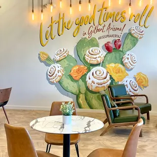 tables and chairs in front of a mural