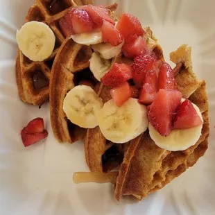 Waffles with 22 grams of protein topped with strawberries,  bananas, and sugar free syrup.