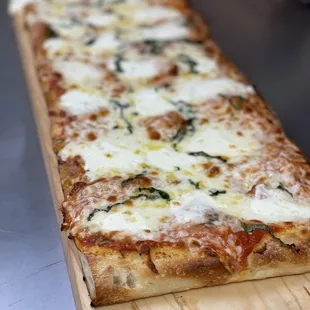 a long rectangular pizza on a cutting board