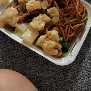 a plate of noodles and meat with chopsticks